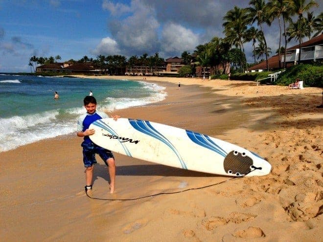 boy holding surfboard in Kauai