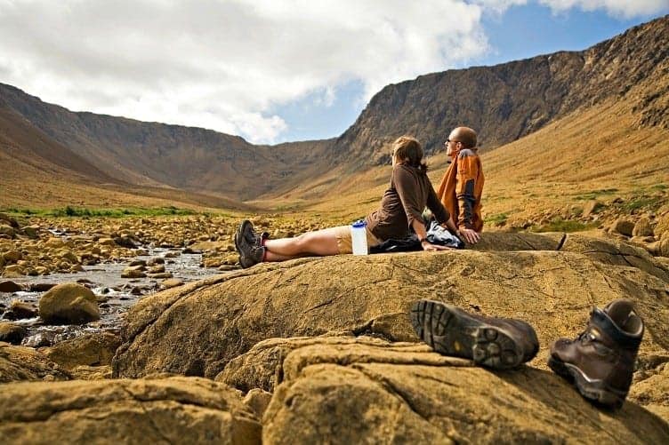 couple sitting in open field camping