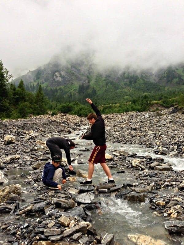boys playing with river stones in adelboden