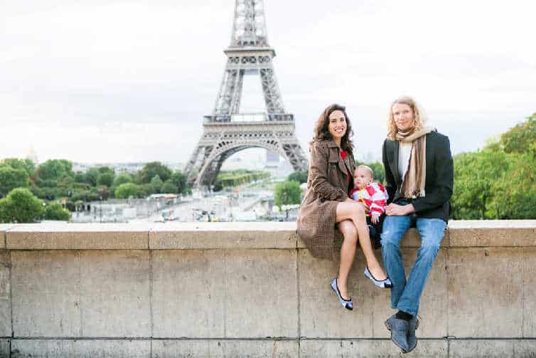 couple with baby in front of eiffel tower