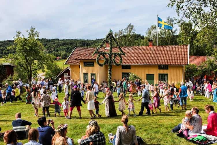 people dancing around midsummer pole in sweden